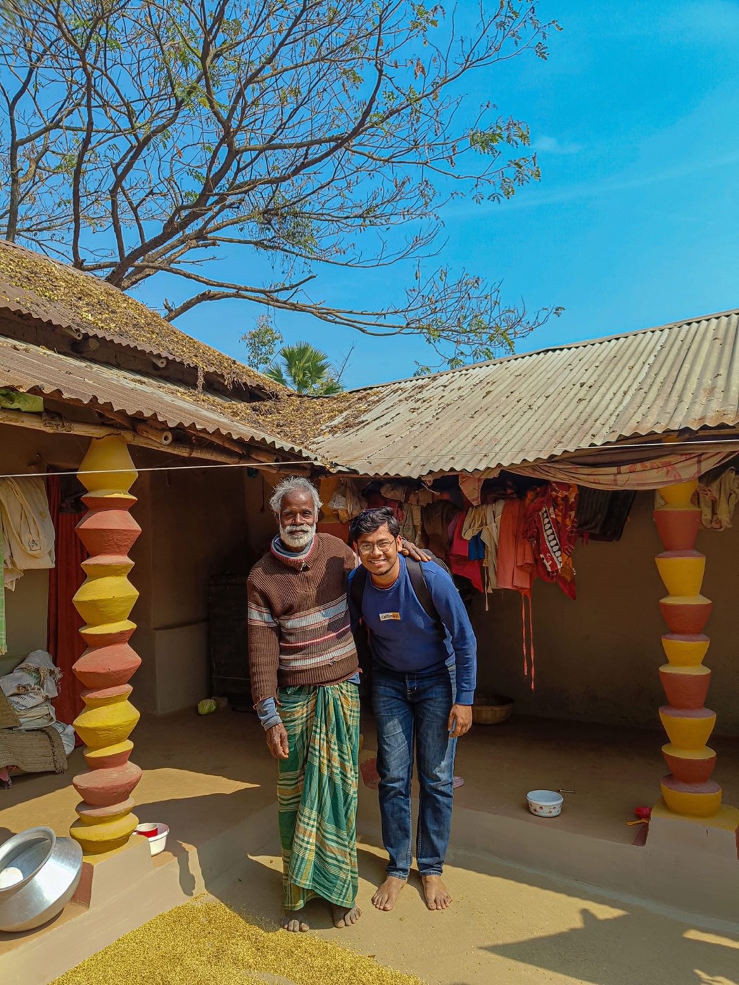Standing with a community member in a village courtyard
